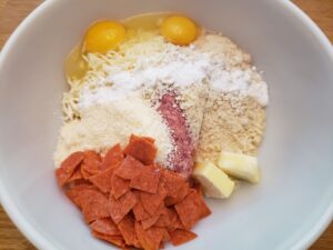 ingredients for Keto Sausage Pizza Bites in mixing bowl