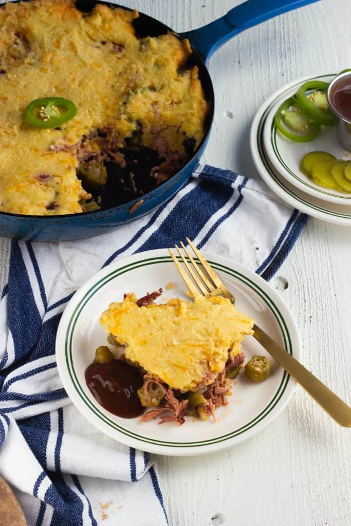 pulled pork and bacon casserole in pan with a piece taken out on a plate